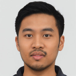 Portrait of a person with a neutral expression against a plain background